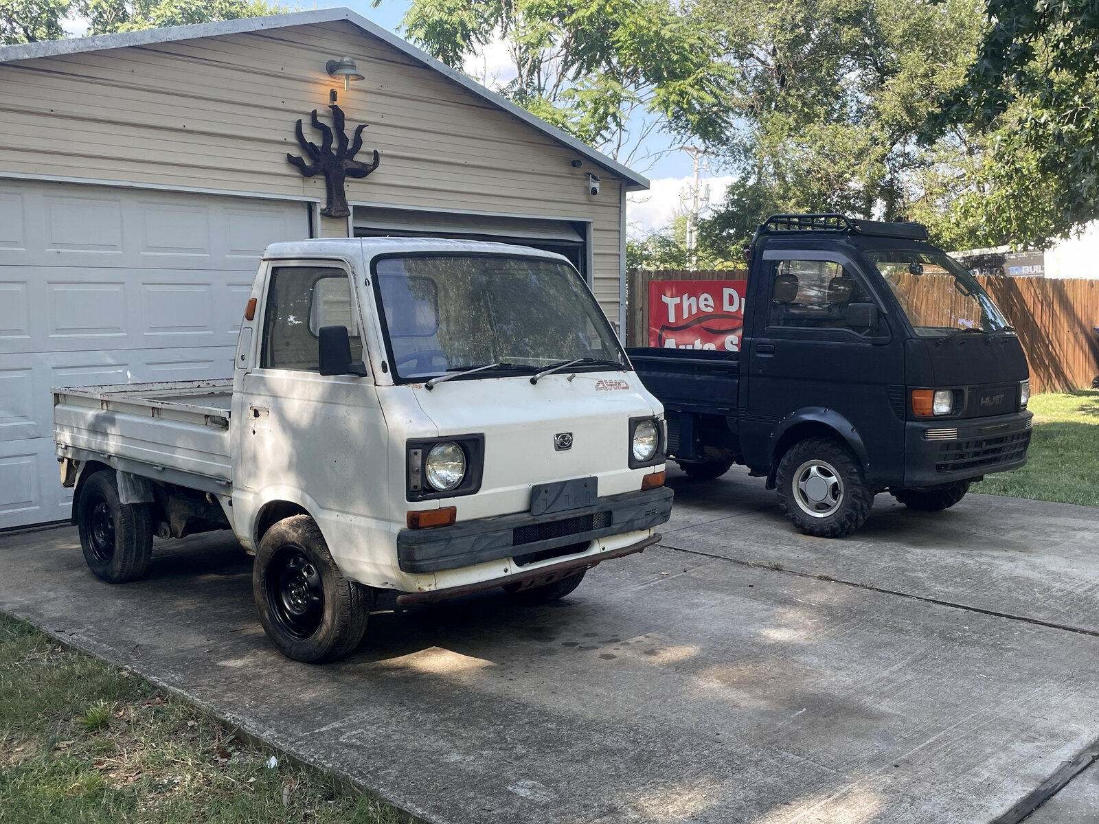 Two compact trucks used by Little Diggers for hauling material