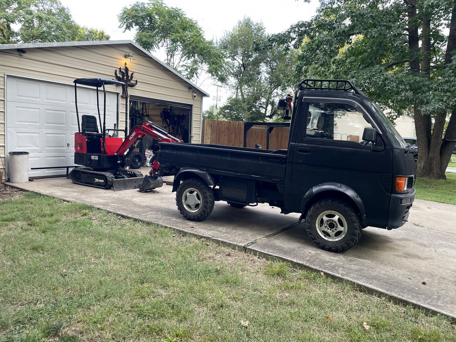 Compact excavator and hauling truck ready for a residential job